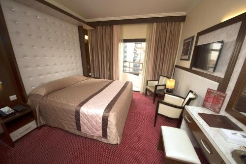 迪拜埃尔卡里大酒店的酒店客房带一张床、一张桌子和椅子