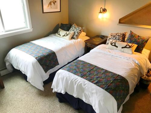 布雷肯里奇Breck Creekside at Wildwood Suites的一间卧室设有两张床和窗户。