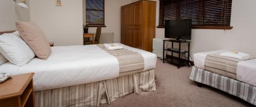 肯图巴拉麦森精品酒店的酒店客房设有两张床和电视。