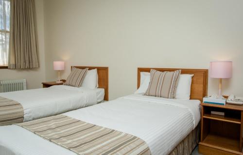 肯图巴拉麦森精品酒店的配有2盏灯的酒店客房的2张床