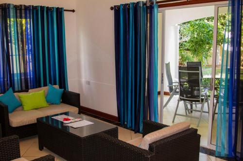马埃岛贝拉扎尔区奥古斯丁公寓酒店的客厅配有沙发和桌子