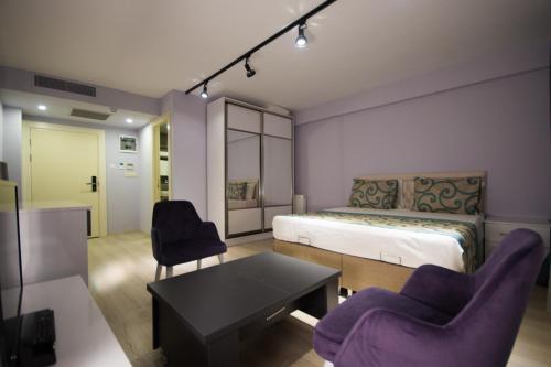 伊斯坦布尔EPS Suite的一间卧室配有一张床、两把椅子和一张桌子