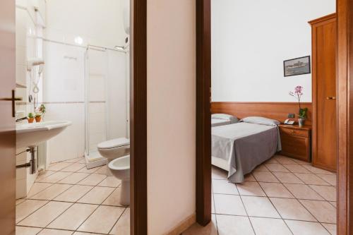 Maierà贝拉维斯塔酒店 的一间卧室设有一张床、一个卫生间和一个水槽
