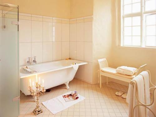 Gudme布罗霍姆城堡酒店的带浴缸的浴室和窗户。
