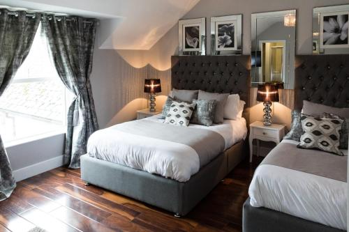 DunmoyleThe Tailor's House Guest Rooms的一间卧室设有两张床和窗户。