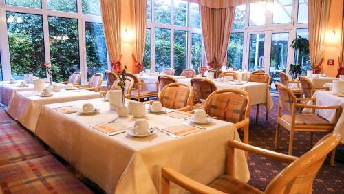 开姆尼茨开姆尼茨公园琥珀酒店的用餐室设有桌椅和窗户。