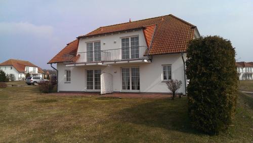 耐德西茨Ferienwohnung Landtraum的白色房子,有橙色屋顶