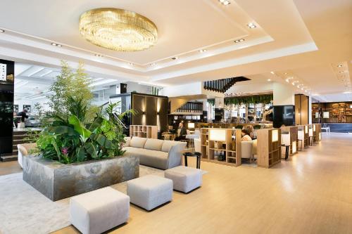 马德里巴拉哈斯美利亚酒店的一个带沙发和椅子的大堂以及一间餐厅