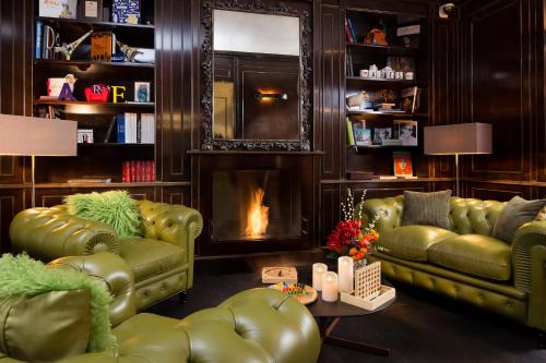 巴黎战神艾菲尔酒店的客厅设有2张绿色真皮沙发和壁炉