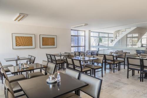 巴西利亚比塔尔酒店的用餐室设有桌椅和窗户。