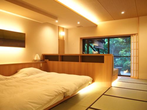 箱根佳松日式旅馆的一间卧室设有一张大床和一个窗户。