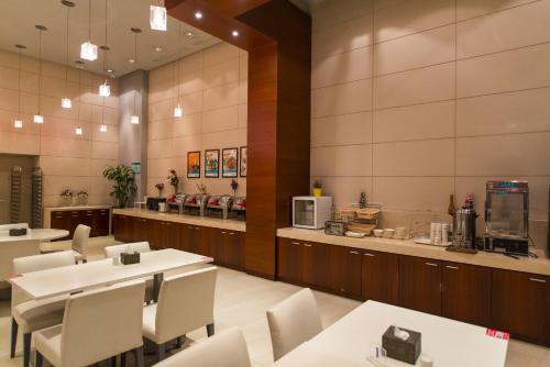 银川锦江之星品尚银川清和南街酒店的餐厅设有白色的桌椅和柜台