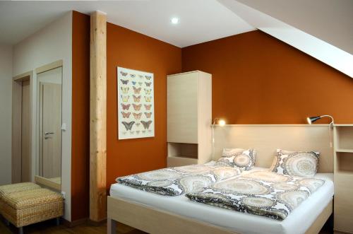 布兰斯科Restaurace Obůrka的一间卧室配有一张橙色墙壁的床