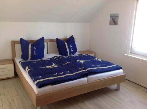 青斯特Haus Irma的卧室内的一张带蓝色毯子和枕头的床