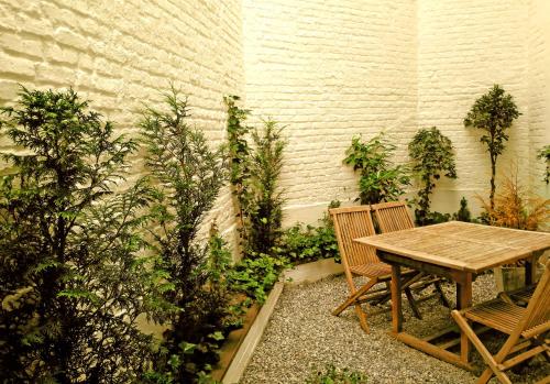 布鲁塞尔德莫特住宿加早餐旅馆的花园里的一张木桌和两把椅子