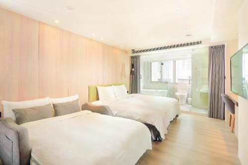 台中市绿宿行旅的酒店客房设有两张床和电视。