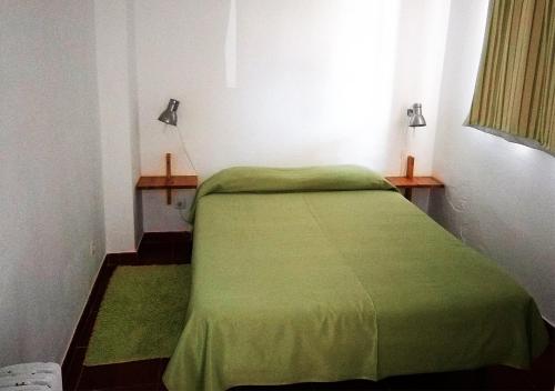 卢斯Parque de Campismo Orbitur Valverde的窗户客房内的一张绿色床