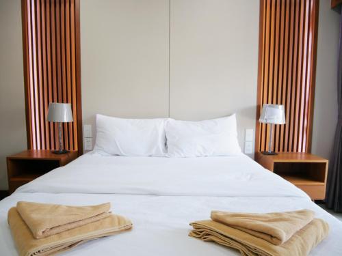 曼谷Room58的卧室配有白色的床和2条毛巾