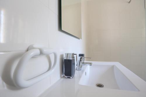 卡斯卡伊斯Suites Apartments的白色的浴室设有水槽和水龙头