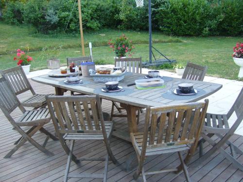 Saint-Paul-dʼIzeaux奥姆布拉格花园住宿加早餐旅馆的一张带椅子的木桌和一碗食物