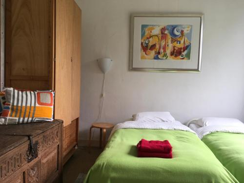 洛赫姆De Akelei的一间卧室配有两张带绿床单的床