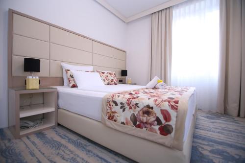 萨拉热窝旧城酒店的一间卧室设有一张大床和一个窗户。