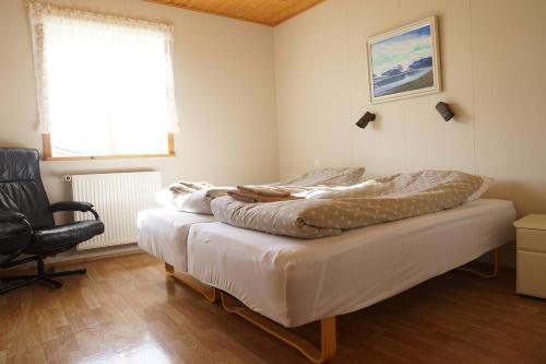 AðaldalurHólmavað Guesthouse的一间卧室配有两张床和椅子