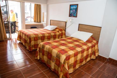 奇格纳瓦潘Hotel Symer的酒店客房设有两张床和窗户。