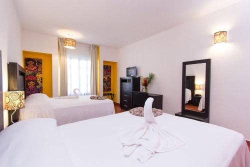 圣克鲁斯华特库Hotel Santa Cruz Huatulco的酒店客房,设有两张床和镜子