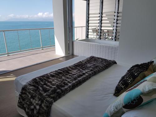 耐莉湾Penthouse on Bright Point的一间卧室设有一张床和一个海景阳台