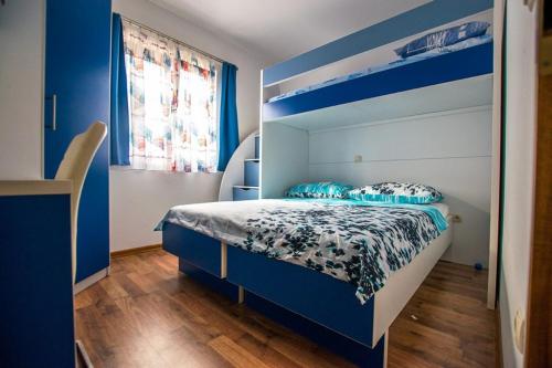 斯塔利格拉德-帕克利尼卡Apartment Andjela的卧室配有蓝色和白色的床和窗户。