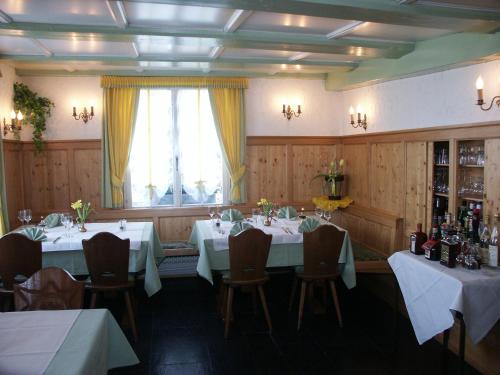 MünsterlingenHotel Garni Sonne的一间带桌椅的用餐室和窗户。