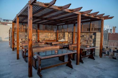 开罗卫报旅馆的屋顶上设有长椅和桌子的木制凉亭
