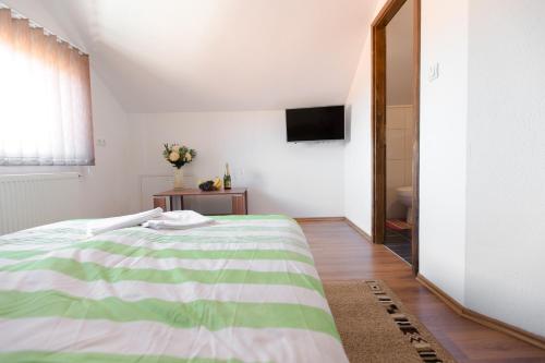 巴尼亚卢卡Guesthouse Vila Puzic的卧室配有绿色和白色的床和镜子