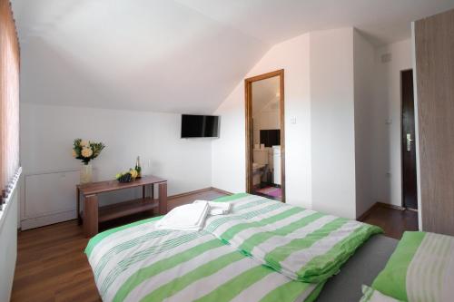 巴尼亚卢卡Guesthouse Vila Puzic的一间卧室配有一张大床和一张桌子