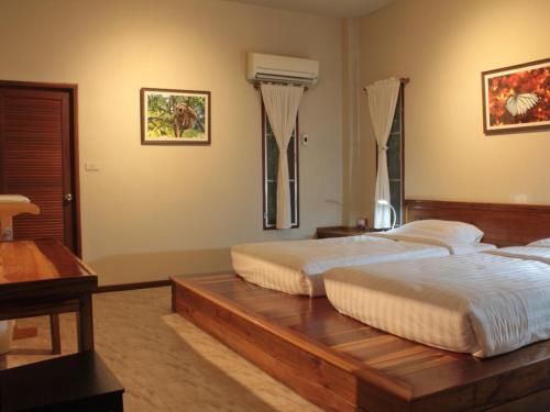 班康卡臣班马卡自然旅馆的一间卧室配有木桌上的两张床