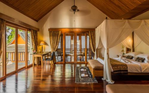 拉威海滩Villa Salika - SHA Plus的一间卧室设有一张床和一个阳台