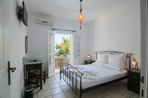 阿吉亚利伊佩里拉酒店的一间卧室配有一张床,阳台设有窗户