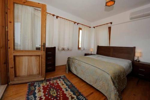 达特恰Villa Olive Garden的卧室配有床、门和地毯