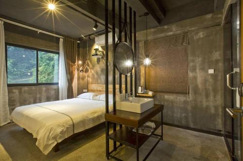 黄山风景区0517客栈的一间卧室配有一张带水槽和镜子的床