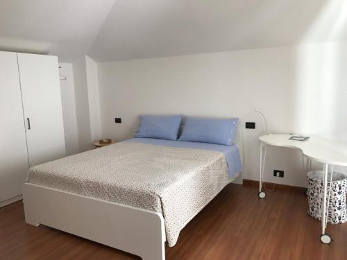 阿科Appartamento Pedrotti的白色卧室配有床和桌子
