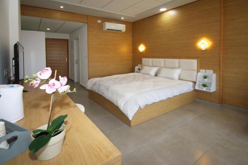迈季代勒舍姆斯סנו נופש בגולן的一间卧室配有一张床和一张带花卉的桌子