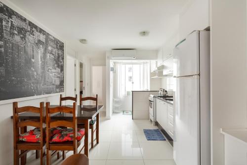 巴拉奈里奥-坎布里乌Apto 2 quartos, 1 quadra do Mar/Shop. Atlantico的厨房配有桌椅和冰箱。