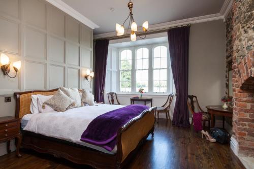 恩尼斯科西威尔顿城堡公寓的一间卧室配有一张床铺,床上铺有紫色毯子