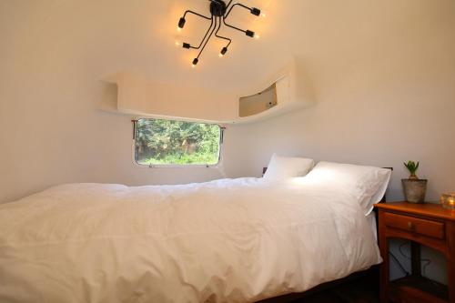奄美奄美冬青露营地清风别墅的卧室配有白色的床和窗户。