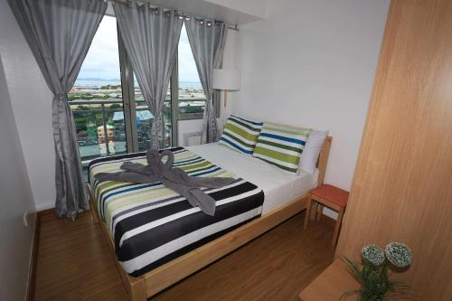 马尼拉茂伊蔚蓝公寓式酒店的一间卧室设有一张大床和大窗户
