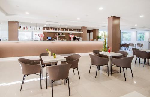帕尔马诺瓦Globales Panamá的一间带桌椅的餐厅和一间酒吧
