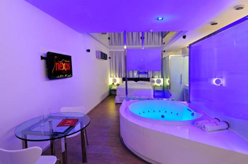 累西腓Nexos Motel Piedade - Adults Only的一间带桌子和床的浴缸的浴室