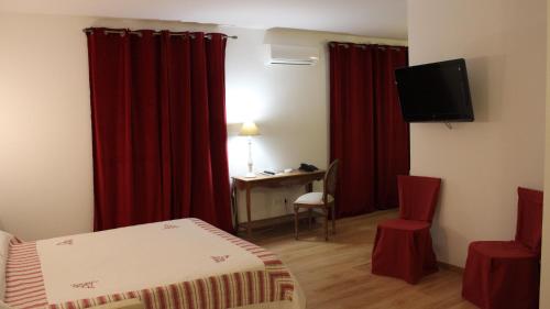 卢恰纳卡斯特路酒店的一间酒店客房,配有红色窗帘、一张床和一张书桌