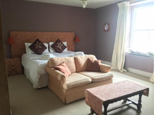 赫恩赫伦肖别墅酒店的一间卧室配有一张床、一张沙发和一张桌子